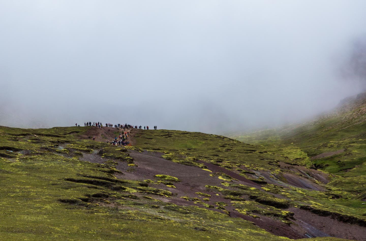 Hikers before the clouds covering Rainbow Mountain, Peru