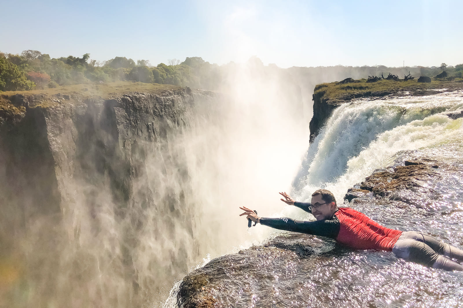 Carlos posing like Superman off the top of Victoria Falls, Zambia