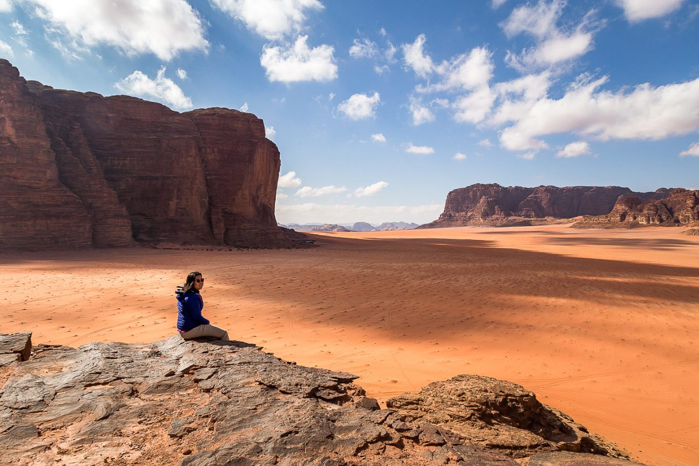 Sitting at the edge of a rock, Wadi Rum, Jordan