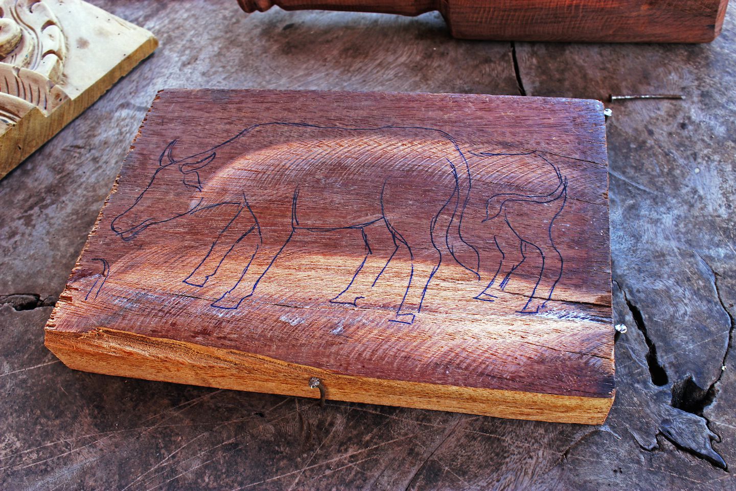 Carlos' drawing on the wood, preparing it for carving, Vientiane, Laos