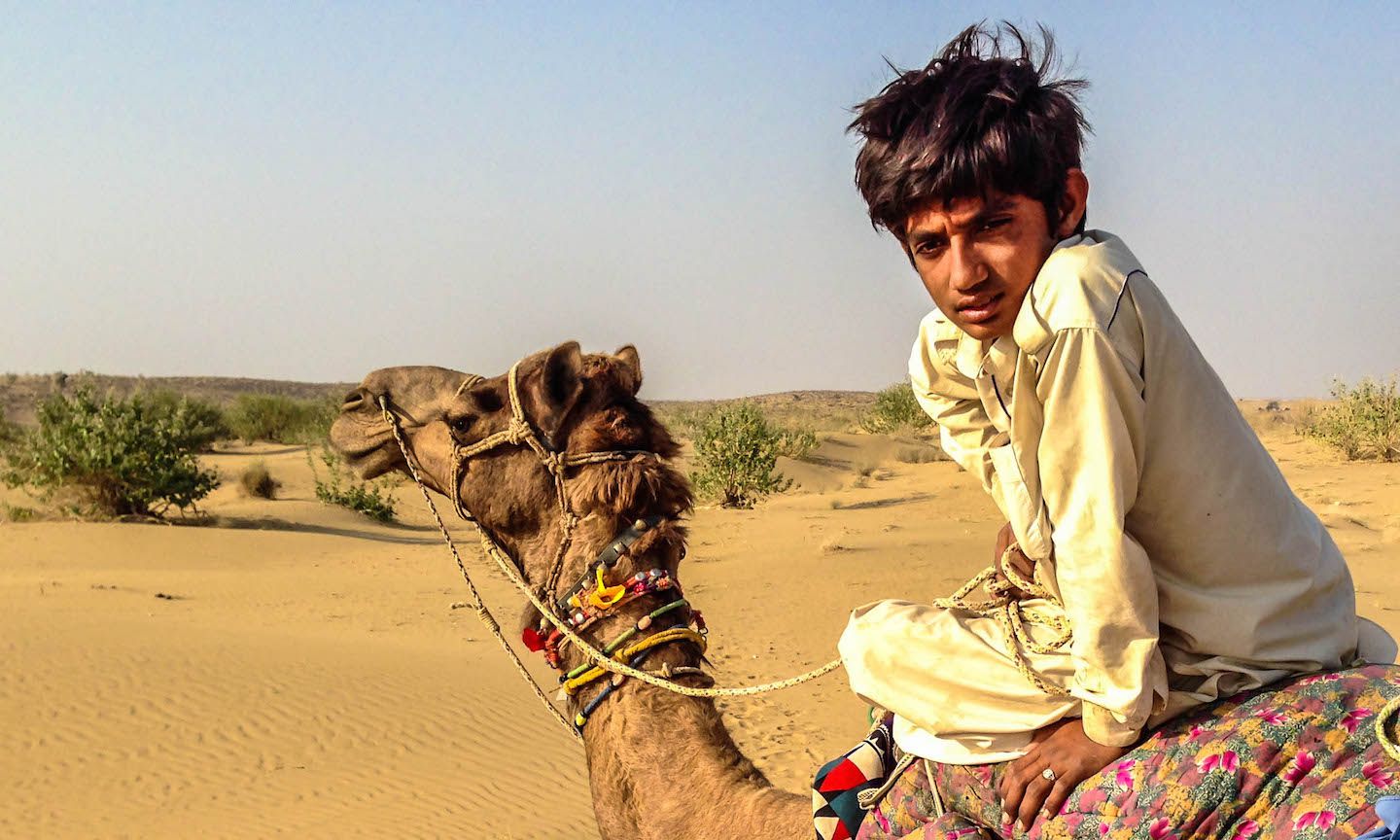 Local riding a camel in the Thar Desert, Jaisalmer, India