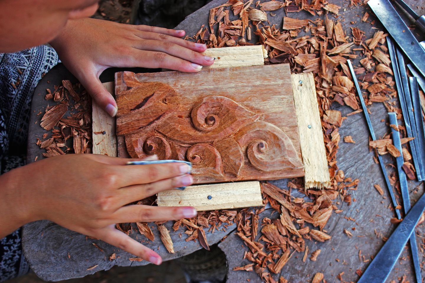 Julie sanding her wood carving, Vientiane, Laos