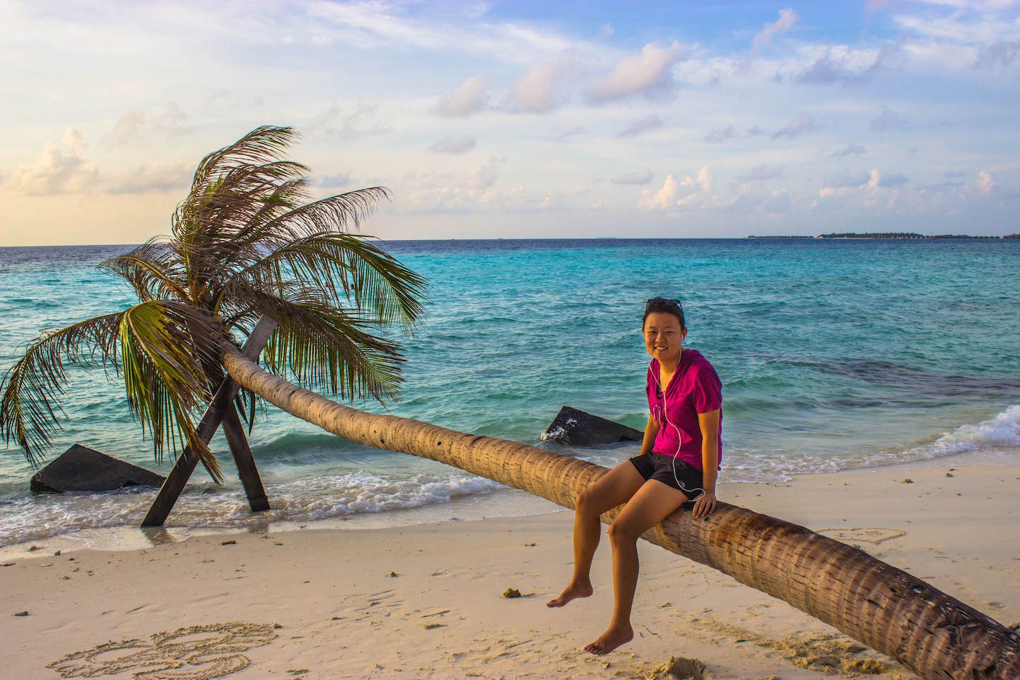Julie sitting on the palm tree, Maafushi, Maldives