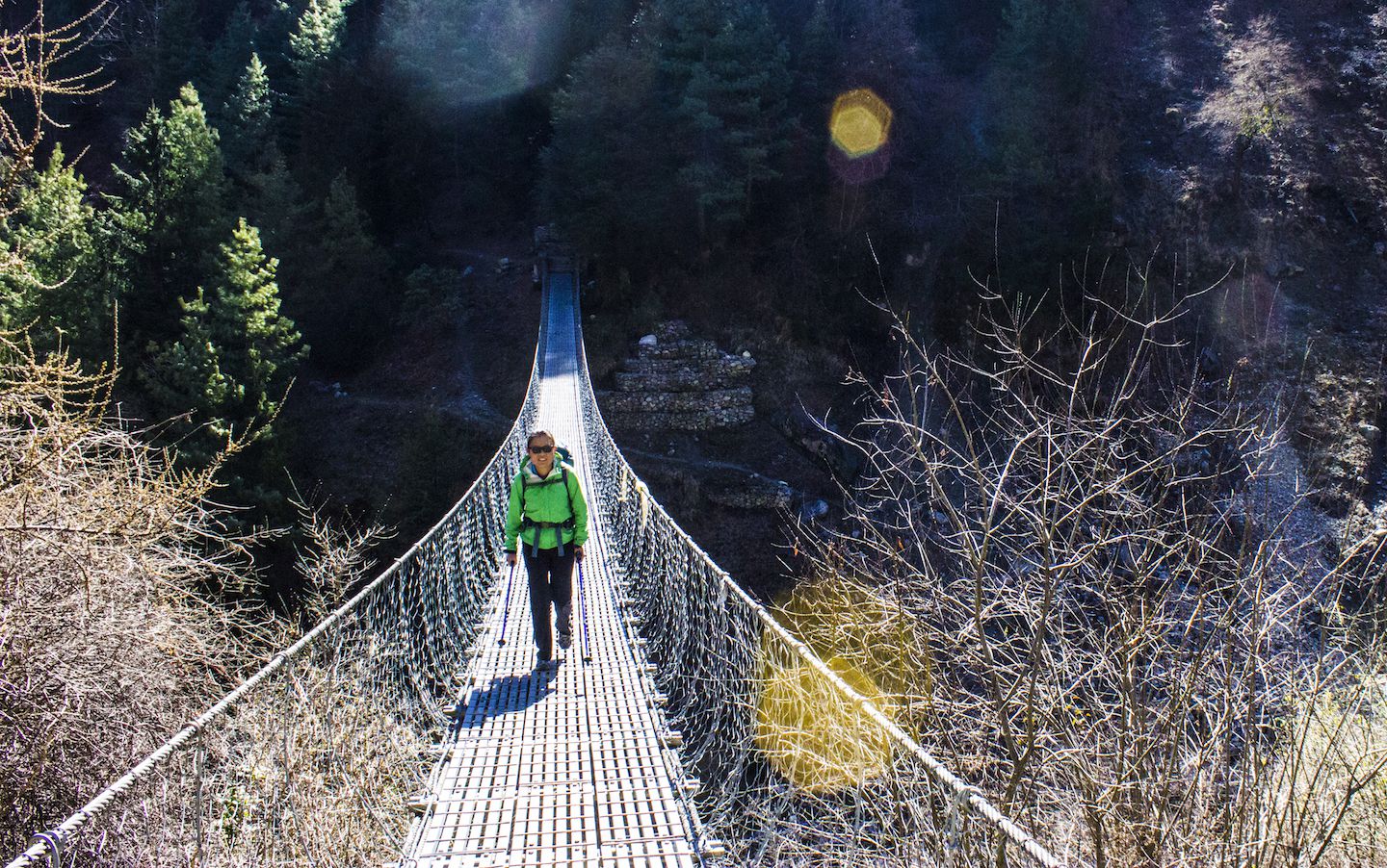 Julie crossing a suspension bridge on the way to Chame, Nepal