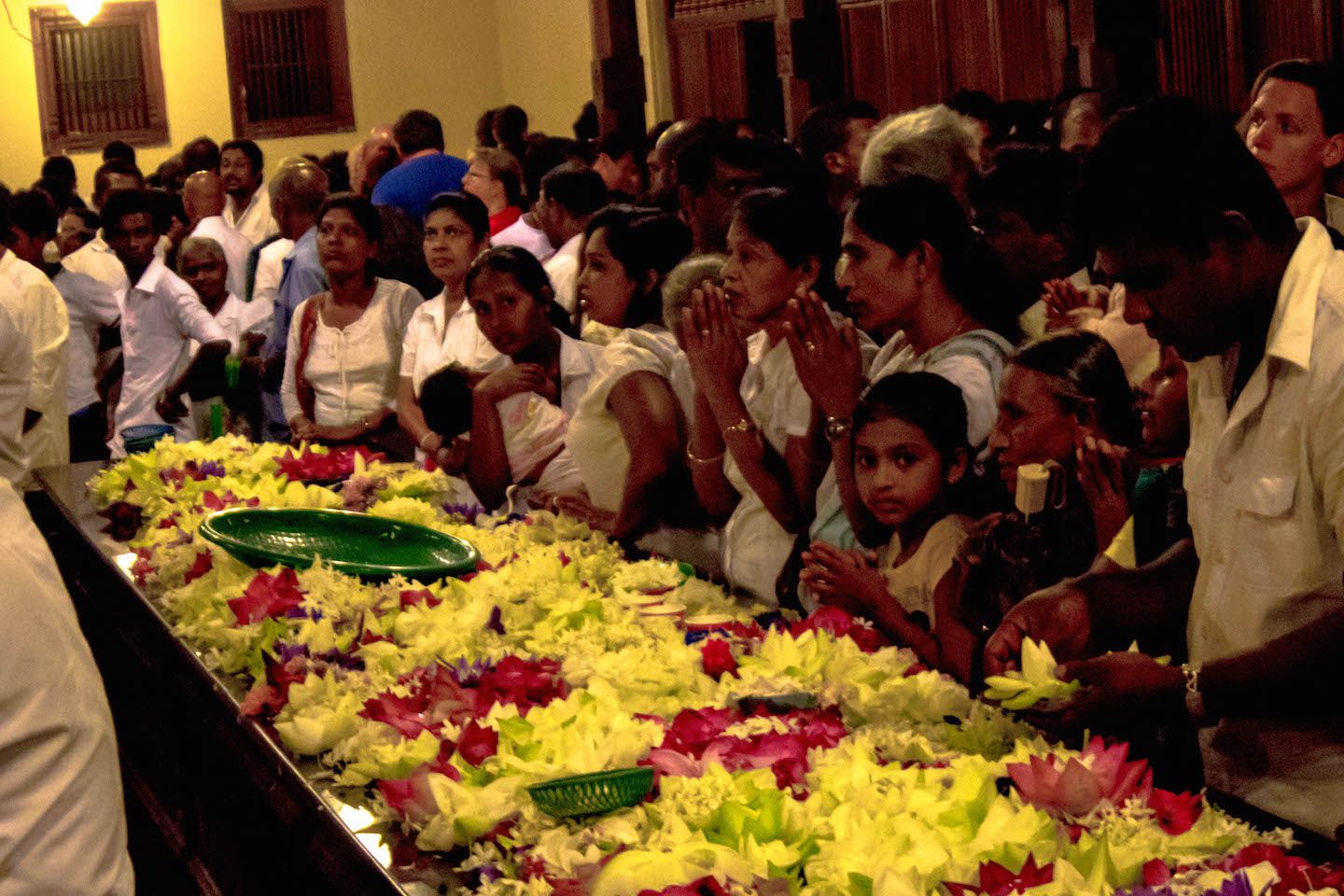 Locals making offerings to Buddha, Kandy, Sri Lanka